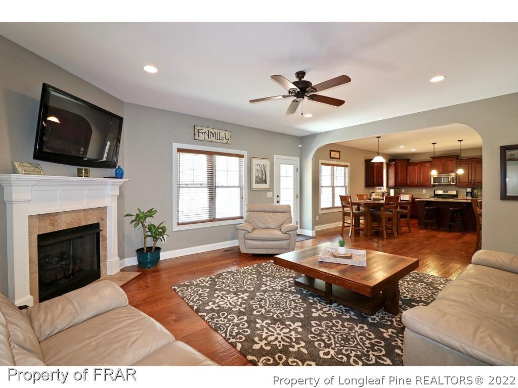 1187 Rays Bridge Road Whispering Pines, NC 28327 - Photo 28 of 35 a living room with fireplace furniture and a flat screen tv