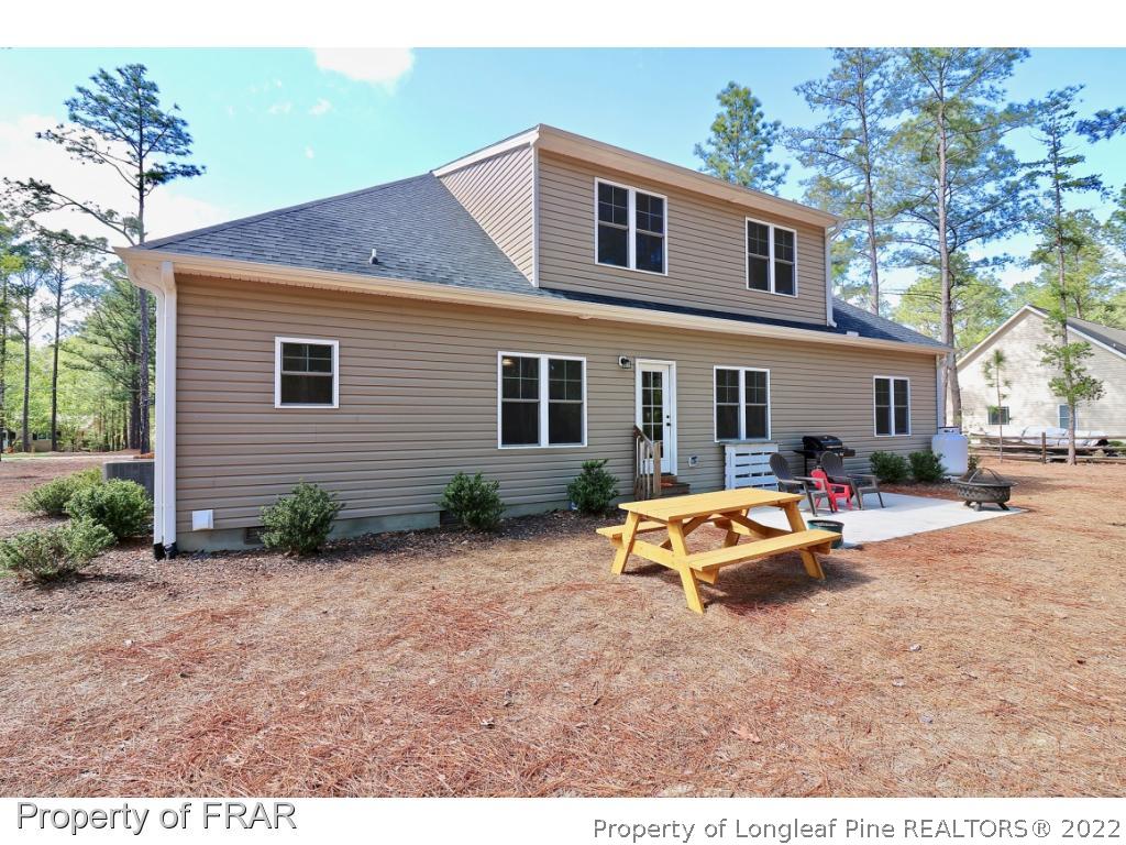 1187 Rays Bridge Road Whispering Pines, NC 28327 - Photo 34 of 35 a backyard of a house with table and chairs