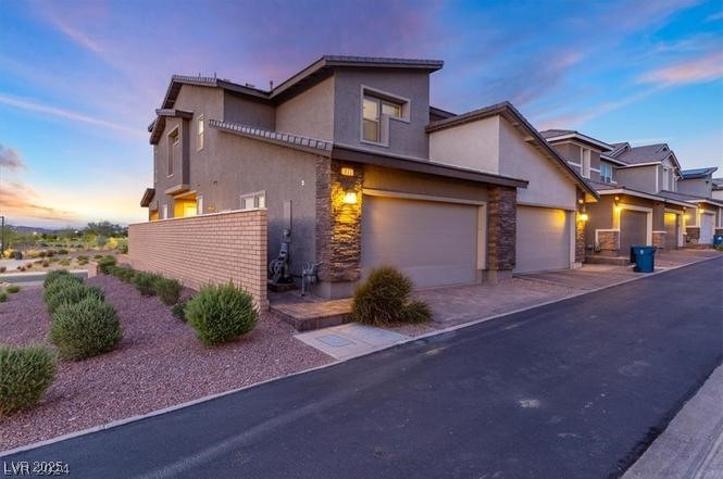 805 East Sunset Road Henderson, NV 89011 - Photo 14 of 43 Traditional-style home with stucco siding, stone siding, driveway, and an attached garage