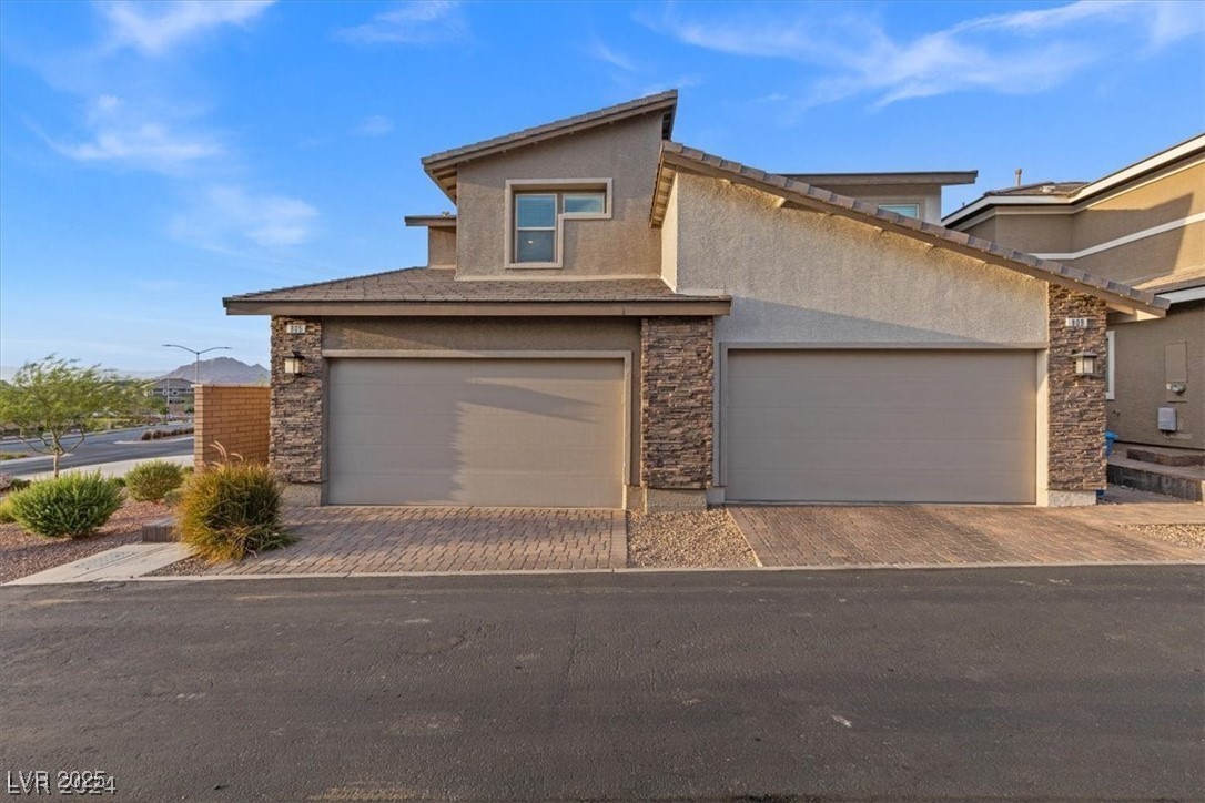 805 East Sunset Road Henderson, NV 89011 - Photo 2 of 43 View of front facade with stone siding, stucco siding, and decorative driveway