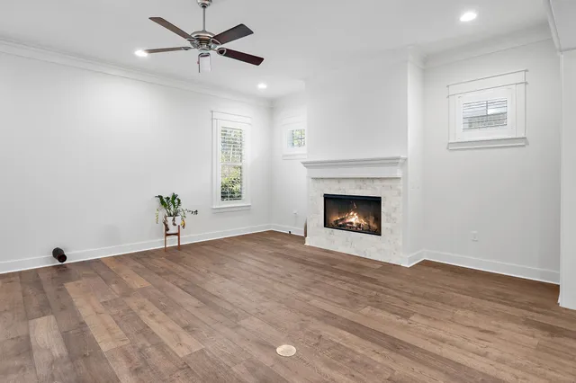 a view of empty room with fireplace and wooden floor