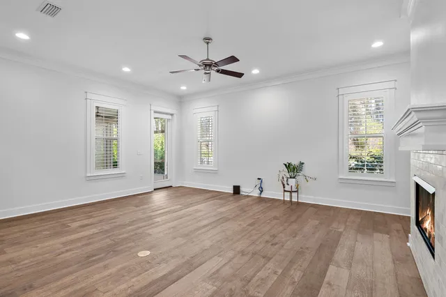 a view of an empty room with a window and wooden floor