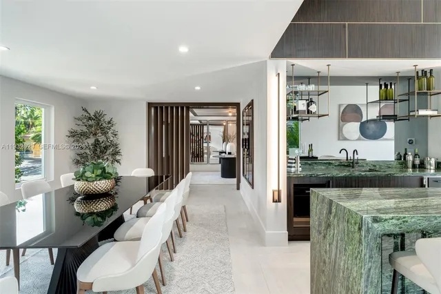 a kitchen with stainless steel appliances kitchen island granite countertop a table chairs in it and wooden floors