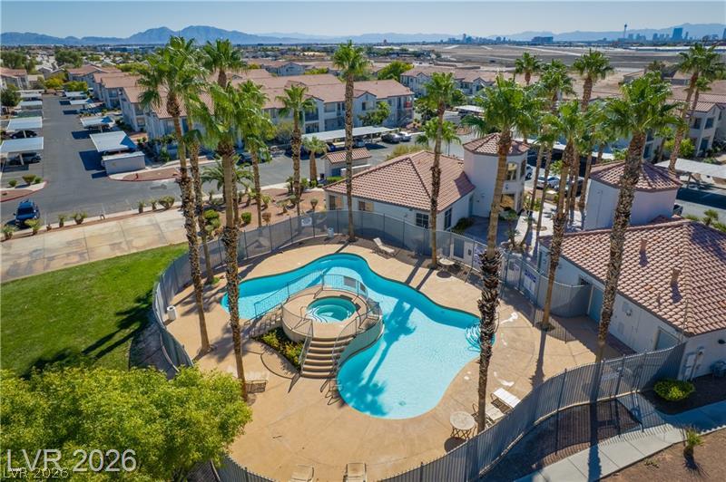 3318 North Decatur Boulevard, Unit 2152 Las Vegas, NV 89130 - Photo 2 of 58 An aerial view captures a refreshing pool and spa surrounded by tall palm trees and community buildings.