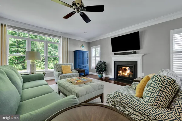a living room with furniture fireplace and a large window