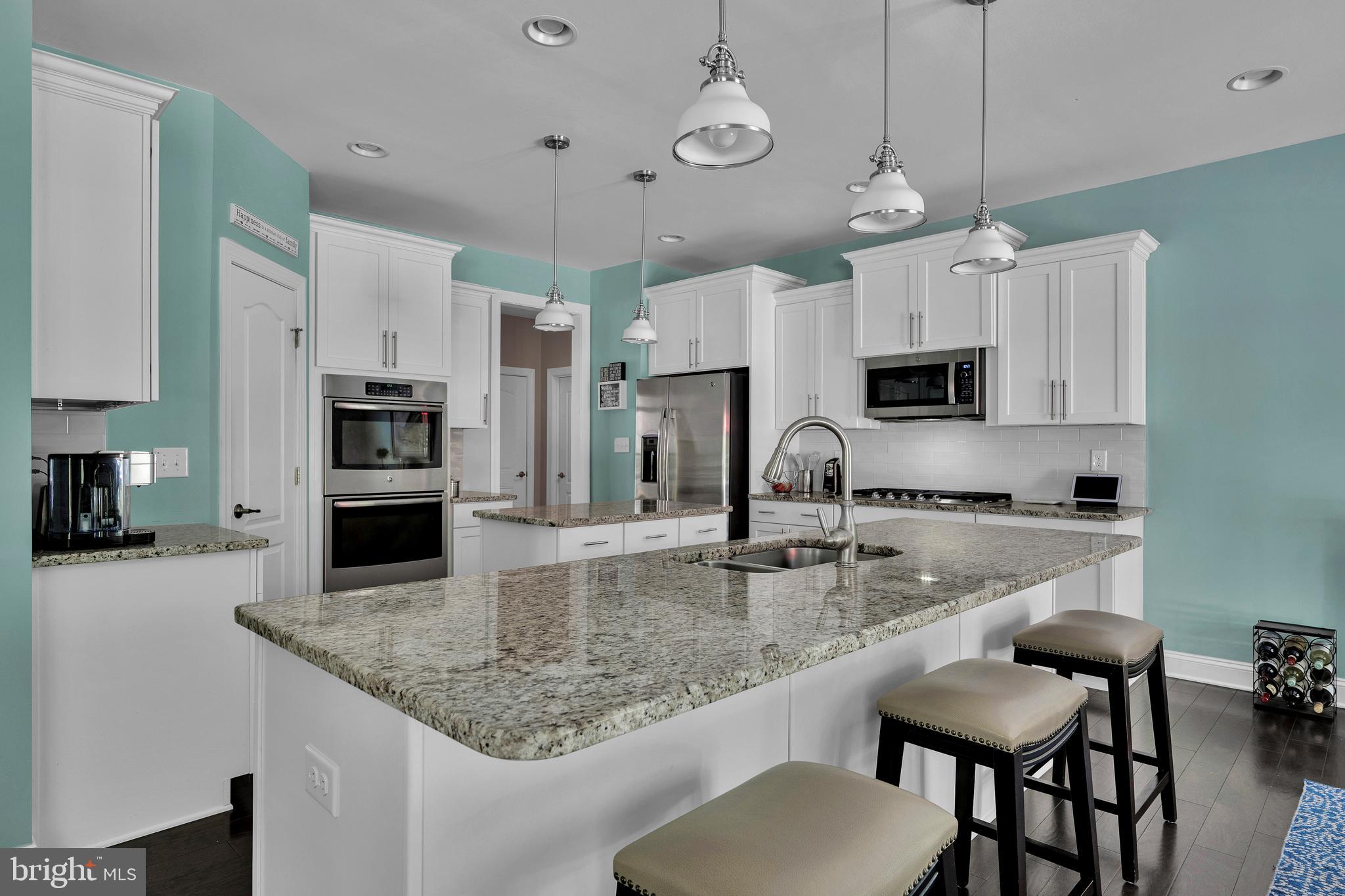18131 Emerson Way Georgetown, DE 19947 - Photo 14 of 52 a kitchen with stainless steel appliances granite countertop a sink a stove top oven a counter space and cabinets