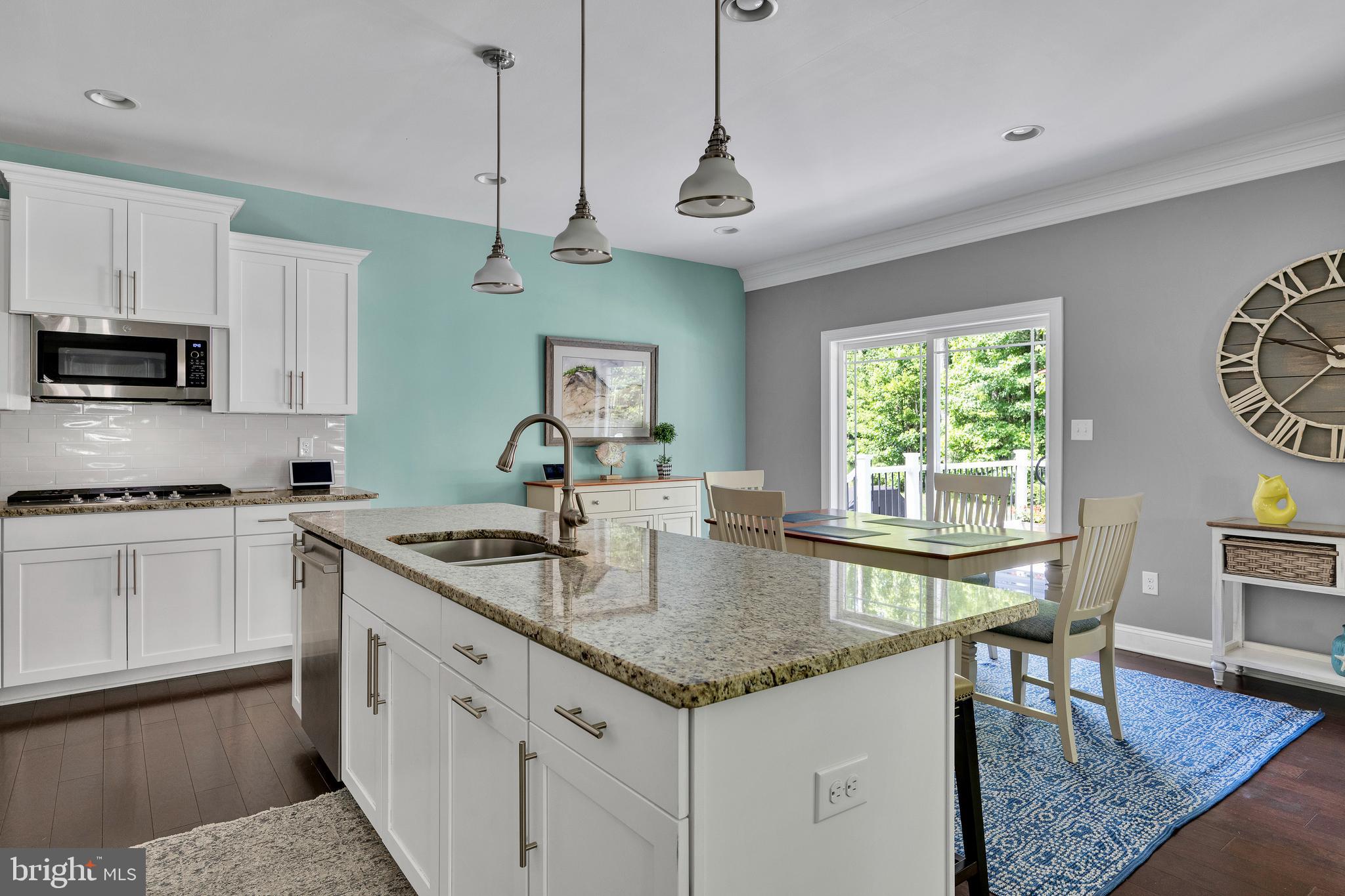 18131 Emerson Way Georgetown, DE 19947 - Photo 17 of 52 a kitchen with granite countertop a stove a sink a dining table and chairs
