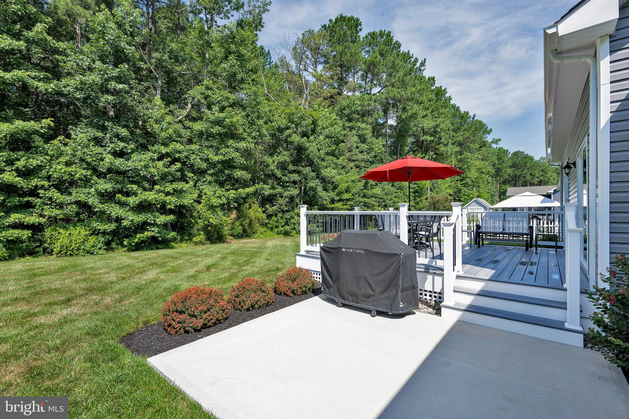 18131 Emerson Way Georgetown, DE 19947 - Photo 36 of 52 a view of a patio with a table and chairs under an umbrella