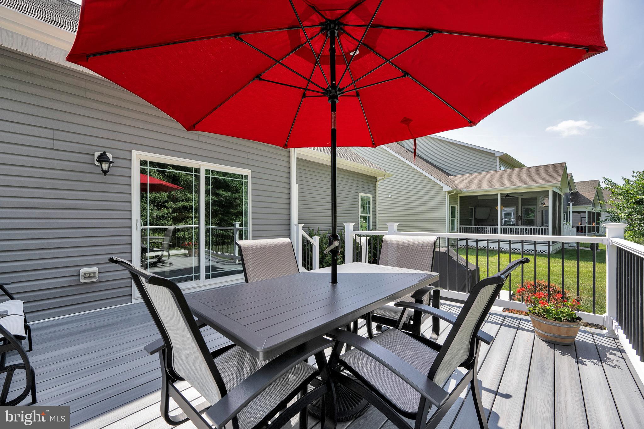 18131 Emerson Way Georgetown, DE 19947 - Photo 37 of 52 a view of a patio with table and chairs under an umbrella
