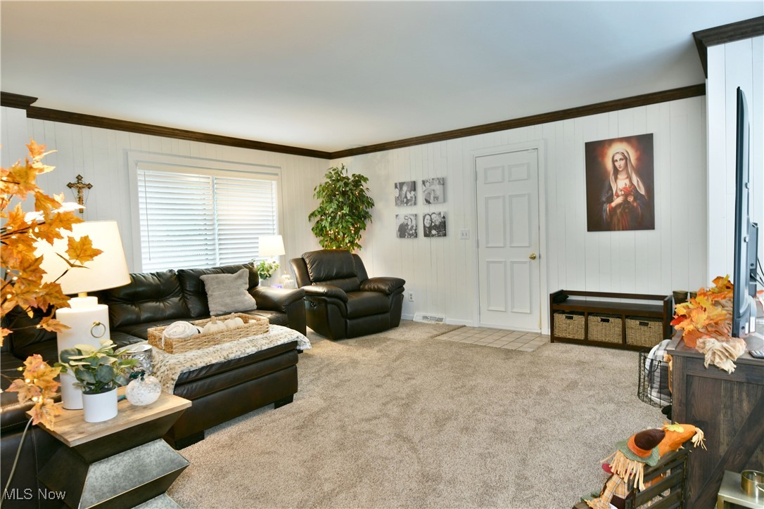 519 Butler Road Northeast Warren, OH 44483 - Photo 11 of 50 Carpeted living room featuring crown molding