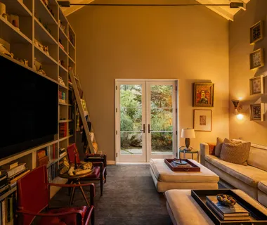 a living room with furniture a flat screen tv and a floor to ceiling window