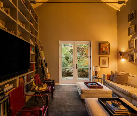a living room with furniture a flat screen tv and a floor to ceiling window