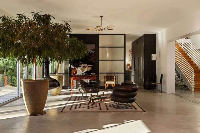 a living room with furniture a window and a potted plant