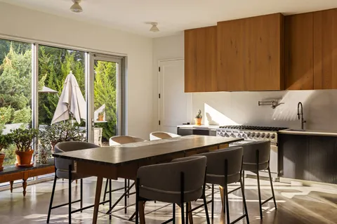 a kitchen with a table chairs and window