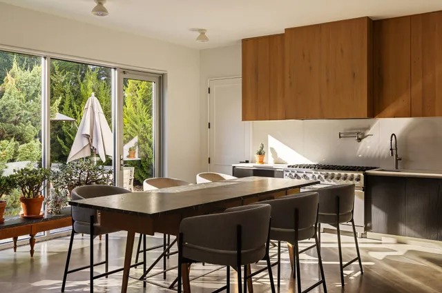 a kitchen with a table chairs and window