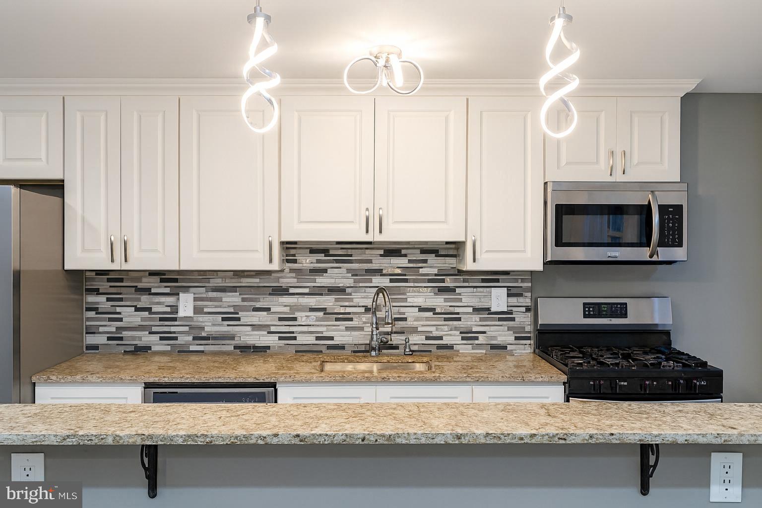 29 Concord Road Darby, PA 19023 - Photo 6 of 21 a kitchen with granite countertop a sink a stove and a microwave