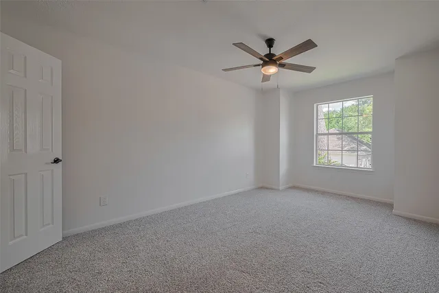 a view of a livingroom with a ceiling fan and window