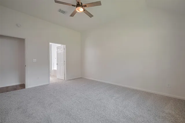a view of an empty room and chandelier fan