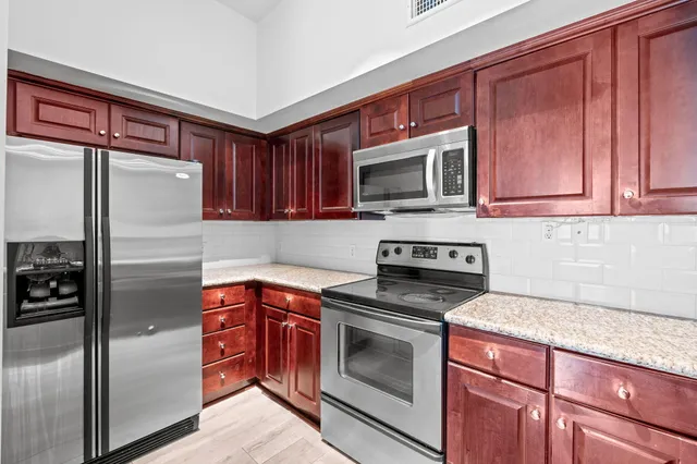 a kitchen with stainless steel appliances granite countertop a sink stove and microwave