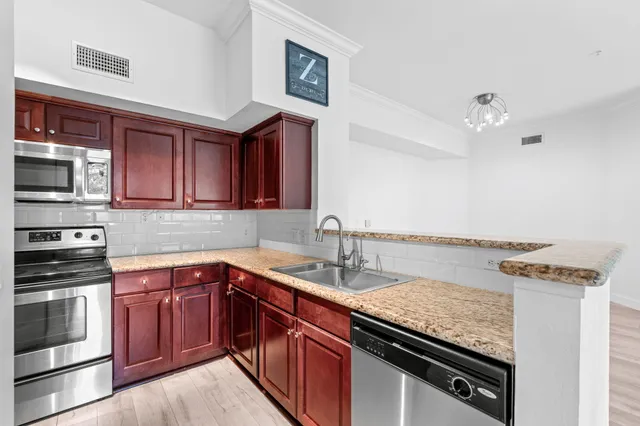 a kitchen with stainless steel appliances granite countertop a sink stove and microwave