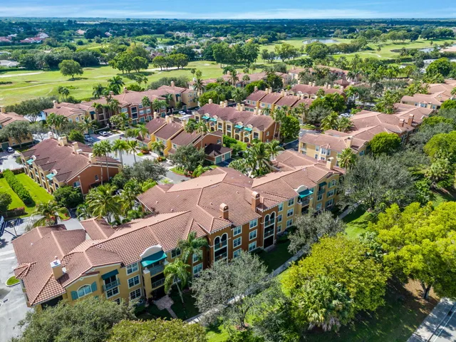 an aerial view of residential houses with outdoor space and trees