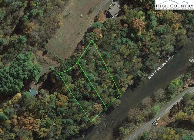 an aerial view of residential house with outdoor space and trees all around