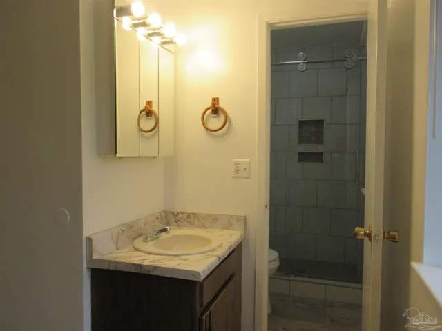 a bathroom with a granite countertop sink and a mirror