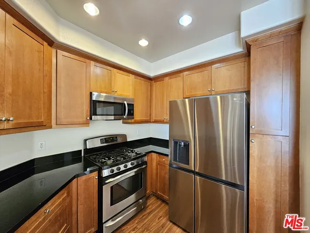 a kitchen with stainless steel appliances granite countertop a refrigerator stove and microwave