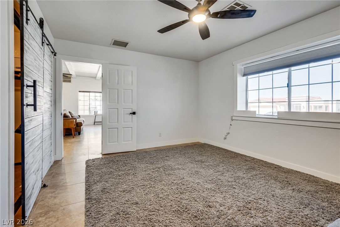 524 Swallow Cove Boulder City, NV 89005 - Photo 29 of 58 A versatile room featuring plush carpet and a stylish barn door, offering comfort and modern design.