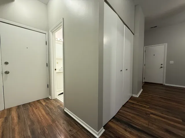 a view of a hallway with wooden floor and staircase
