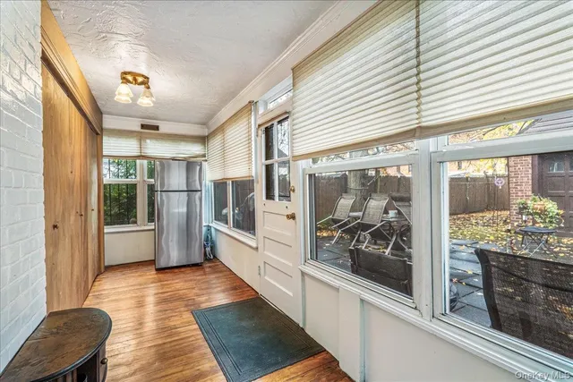 a view of a hallway with wooden floor and furniture