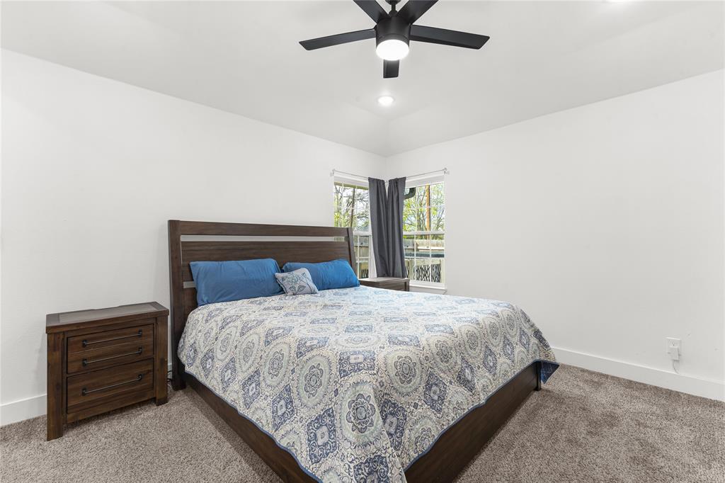 101 Ross Street Sulphur Springs, TX 75482 - Photo 12 of 30 Bedroom featuring a ceiling fan, carpet, and vaulted ceiling