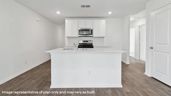 a kitchen with kitchen island a stove a sink and a refrigerator