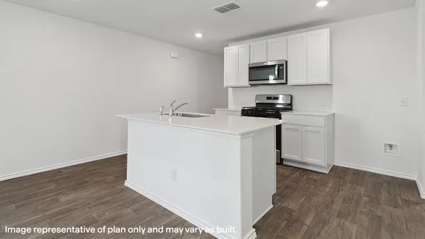 a kitchen with granite countertop a sink stove and microwave