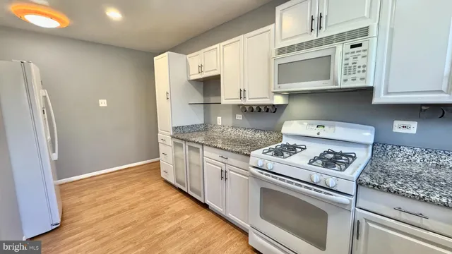 a kitchen with stainless steel appliances granite countertop a stove a microwave and a refrigerator