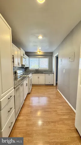 a large kitchen with cabinets and wooden floor