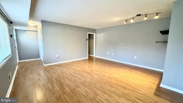 a view of empty room with wooden floor