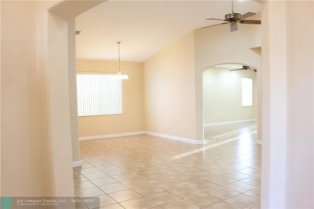 an empty room and chandelier fan