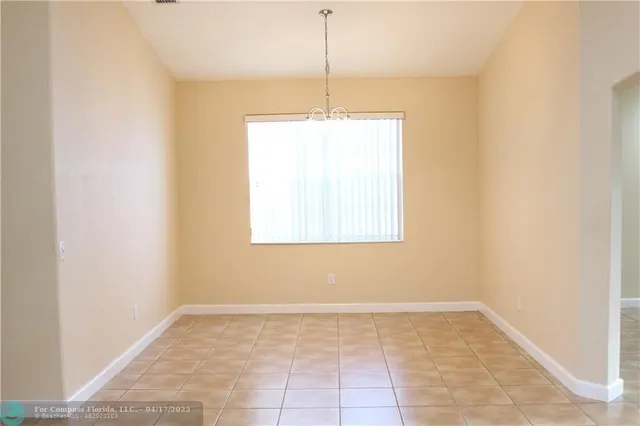 a view of a room with a chandelier fan and window