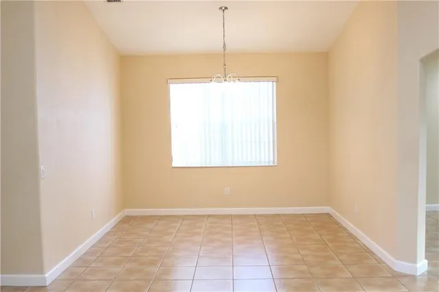 a view of a room with a chandelier fan and window