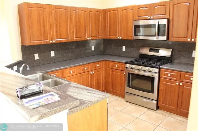 a kitchen with stainless steel appliances granite countertop a sink stove and microwave