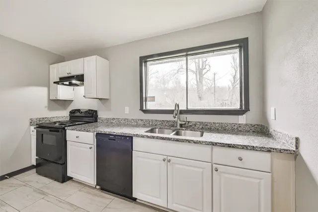 a kitchen with stainless steel appliances granite countertop white cabinets and a granite counter tops