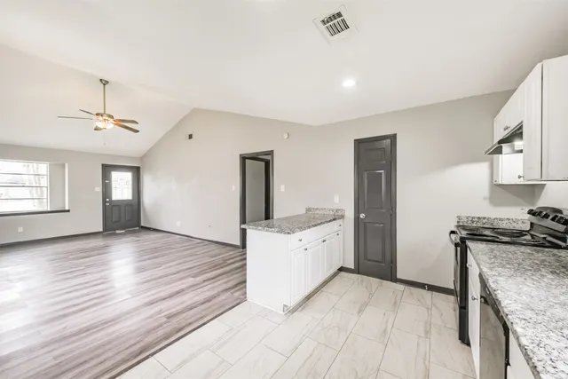 a kitchen with granite countertop a stove and a sink