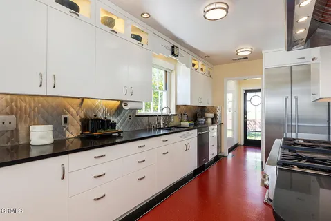 a kitchen with granite countertop white cabinets and stainless steel appliances