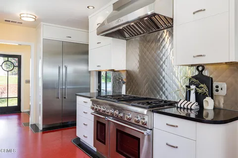 a kitchen with granite countertop a stove and a refrigerator