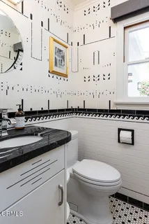 a bathroom with a granite countertop sink and a toilet