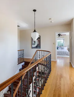 a view of a hallway with wooden floor and stairs