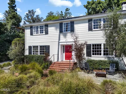 a front view of house with yard and trees in the background