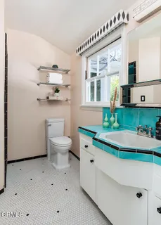 a bathroom with a sink a toilet and a mirror