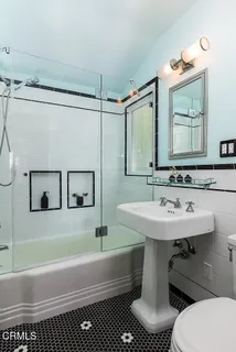 a bathroom with a sink a toilet and a mirror